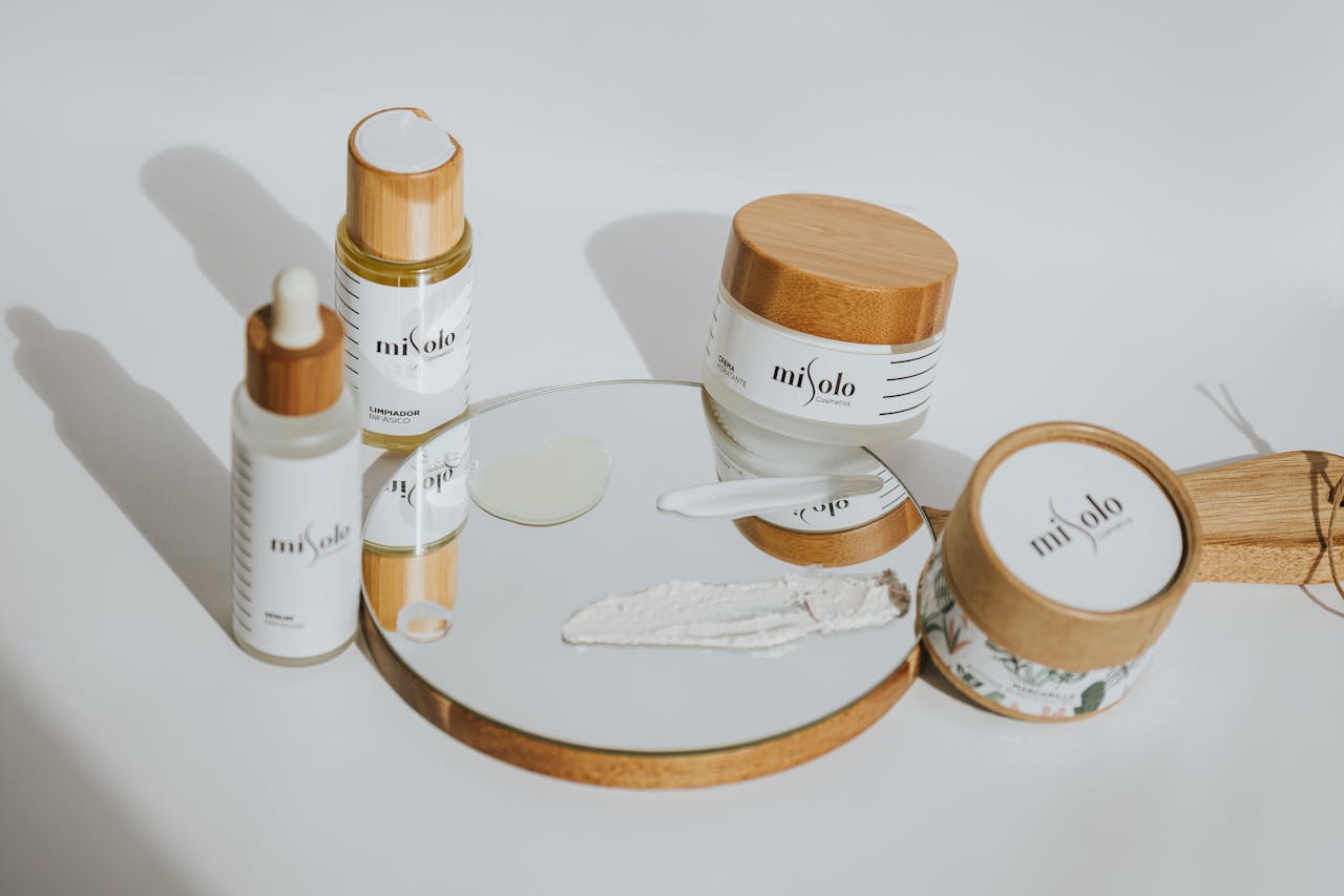 A set of eco-friendly skincare products with bamboo packaging displayed on a mirrored surface.